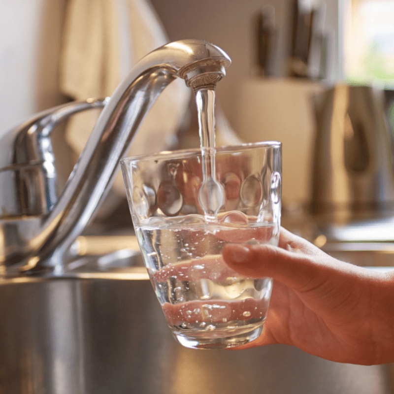 tap water pouring into a glass of water