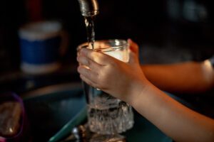 hands of child washing dishes