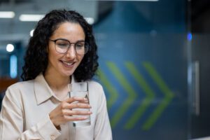 young woman drinking water at work