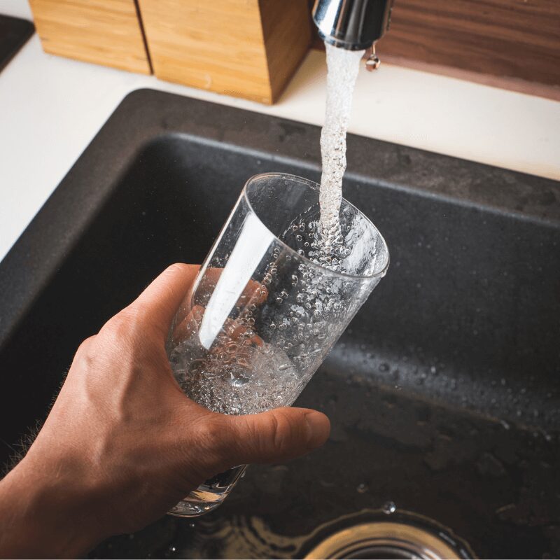 filling a glass of water at the sink